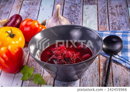 Borsch soup in black bowl with fresh vegetables on rustic wooden table Borsch soup in black bowl with fresh vegetables on rustic wooden table 142459966
