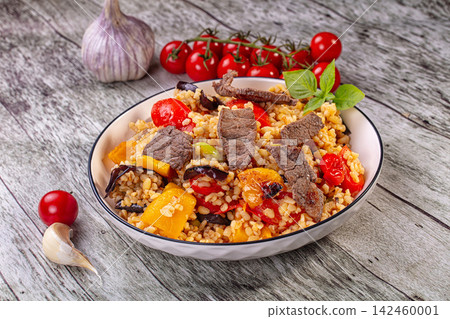 Bowl of bulgur with beef and roasted vegetables on rustic wood Bowl of bulgur with beef and roasted vegetables on rustic wood 142460001