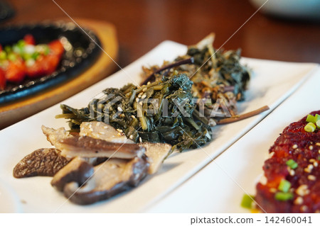 Assorted Korean traditional seasoned vegetables and mushrooms banchan served elegantly on a plate, healthy vegan food side-dishes Assorted Korean traditional seasoned vegetables and mushrooms banchan served elegantly on a plate, healthy vegan food side-dishes 142460041