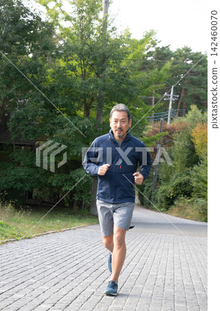 Senior man jogging in a forest with autumn leaves. Running, jogging. Senior man jogging in a forest with autumn leaves. Running, jogging. 142460070