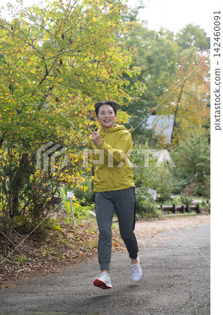 A woman in her 50s running and jogging with a refreshing air. A woman in her 50s running and jogging with a refreshing air. 142460091