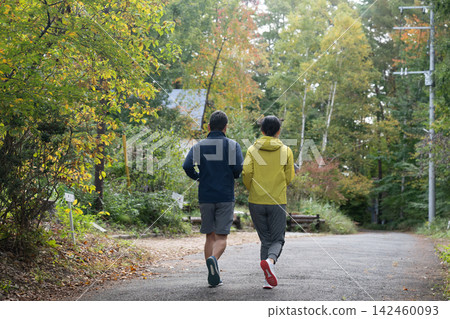 一對情侶沿著山路奔跑,背影清晰可見。跑步,慢跑。 一對情侶沿著山路奔跑,背影清晰可見。跑步,慢跑。 142460093