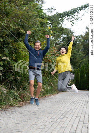 一對中年夫婦又蹦又跳,跑又慢,臉上洋溢著喜悅。 一對中年夫婦又蹦又跳,跑又慢,臉上洋溢著喜悅。 142460152