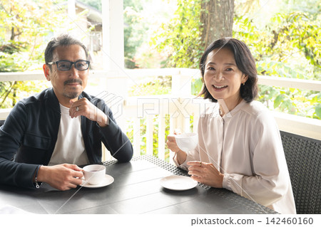 A couple taking a break at a cafe in a highland resort; running, jogging. 142460160