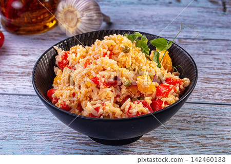 Fried rice with vegetables and egg in black bowl on rustic wood Fried rice with vegetables and egg in black bowl on rustic wood 142460188