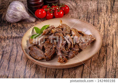 Roasted pulled lamb meat on rustic plate with fresh garlic and cherry tomatoes Roasted pulled lamb meat on rustic plate with fresh garlic and cherry tomatoes 142460198