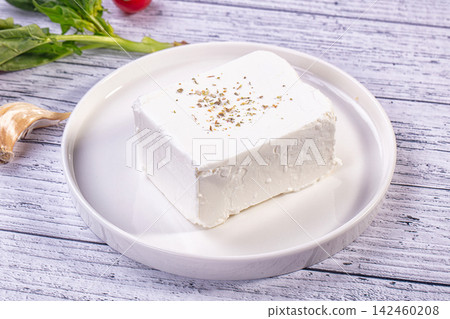 Fresh feta cheese with oregano on white plate with garlic and spinach Fresh feta cheese with oregano on white plate with garlic and spinach 142460208