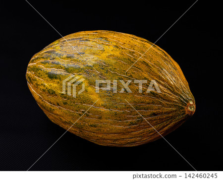 Ripe piel de sapo melon on dark textured surface with warm lighting and natural texture details Ripe piel de sapo melon on dark textured surface with warm lighting and natural texture details 142460245