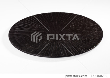 Black textured circular plate with radial pattern on white background Black textured circular plate with radial pattern on white background 142460299