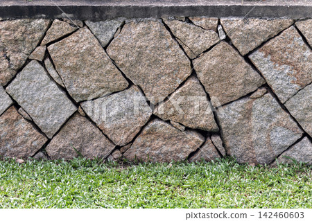 Close-up of a rustic granite stone wall with irregular fitted stones Close-up of a rustic granite stone wall with irregular fitted stones 142460603