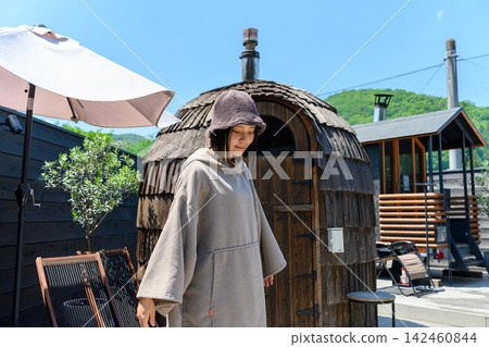 一位女士站在桑拿房前,神情放鬆。 一位女士站在桑拿房前,神情放鬆。 142460844