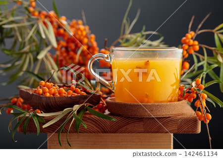 Glass mug of sea buckthorn tea. Glass mug of sea buckthorn tea. 142461134