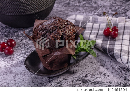 Chocolate muffin with cherries and mint on rustic surface Chocolate muffin with cherries and mint on rustic surface 142461204