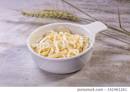 Udon noodles in white ceramic bowl with wheat stalks on rustic wooden surface Udon noodles in white ceramic bowl with wheat stalks on rustic wooden surface 142461261