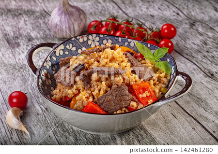 Bulgur pilaf with beef and bell peppers in ceramic bowl Bulgur pilaf with beef and bell peppers in ceramic bowl 142461280