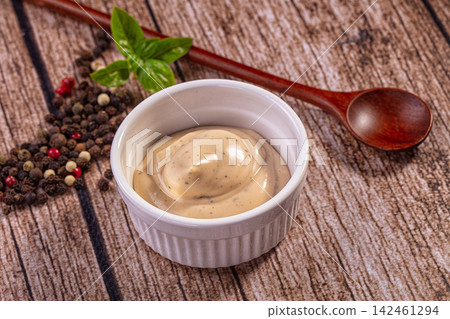 Creamy sauce in white ramekin with peppercorns and basil on rustic wood Creamy sauce in white ramekin with peppercorns and basil on rustic wood 142461294