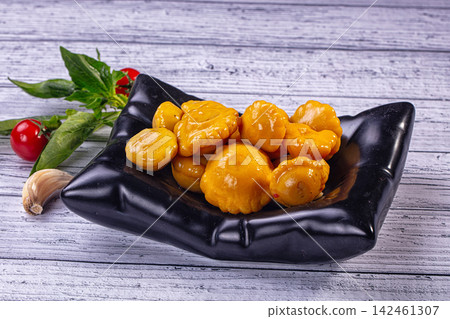Pickled yellow patisson squash in black bowl on rustic wooden table with fresh tomatoes and garlic Pickled yellow patisson squash in black bowl on rustic wooden table with fresh tomatoes and garlic 142461307