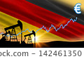Mechanical oil pumps work beneath the waving national flag. Financial graph lines point to high market gains. 142461350