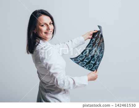 Doctor attentively examines the MRI scan of the patient. Doctor attentively examines the MRI scan of the patient. 142461530