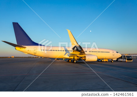 Modern passenger jet plane at the airport in the evening light near shuttle bus Modern passenger jet plane at the airport in the evening light near shuttle bus 142461561