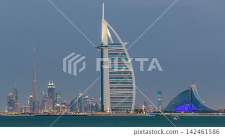 Dubai skyline with Burj Al Arab hotel during sunset and day to night timelapse. Dubai skyline with Burj Al Arab hotel during sunset and day to night timelapse. 142461586