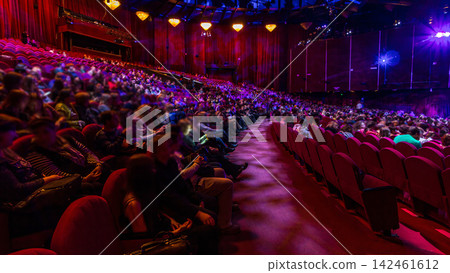 Spectators gather in the auditorium and watch the show in theatre timelapse. Large hall with red armchairs seats Spectators gather in the auditorium and watch the show in theatre timelapse. Large hall with red armchairs seats 142461612