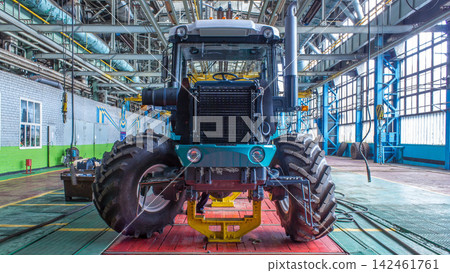 Conveyor assembly stage the body of tractor at big industrial factory timelapse Conveyor assembly stage the body of tractor at big industrial factory timelapse 142461761
