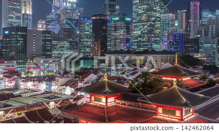 The Buddha Tooth Relic Temple comes alive at night in Singapore Chinatown day to night timelapse, with the city skyline in the background. The Buddha Tooth Relic Temple comes alive at night in Singapore Chinatown day to night timelapse, with the city skyline in the background. 142462064