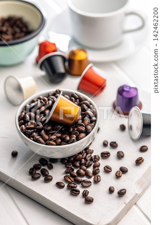 Golden Coffee Capsule Resting on Roasted Coffee Beans in Bowl With Colorful Pods Golden Coffee Capsule Resting on Roasted Coffee Beans in Bowl With Colorful Pods 142462200
