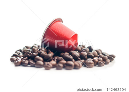 Red Coffee Capsule on Roasted Coffee Beans With White Background and Espresso Aroma Red Coffee Capsule on Roasted Coffee Beans With White Background and Espresso Aroma 142462204