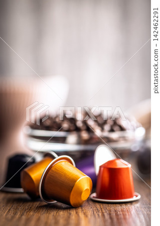 Colorful Coffee Capsules and Espresso Pods With Bowl of Roasted Coffee Beans on Wooden Table Colorful Coffee Capsules and Espresso Pods With Bowl of Roasted Coffee Beans on Wooden Table 142462291
