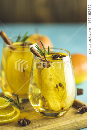 Festive summer drinks, pear spice cocktail. Hot drink cocktail for Christmas, winter or autumn holidays. Served with ingredients on light blue surface Festive summer drinks, pear spice cocktail. Hot drink cocktail for Christmas, winter or autumn holidays. Served with ingredients on light blue surface 142462422