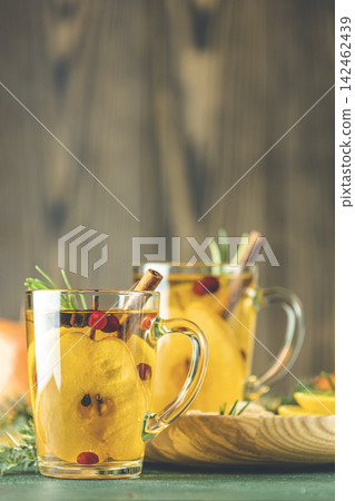 Two glass cup of festive winter drinks, pear cider spice cocktail. Hot drink cocktail for Christmas, winter or autumn holidays. Copy space for you text Two glass cup of festive winter drinks, pear cider spice cocktail. Hot drink cocktail for Christmas, winter or autumn holidays. Copy space for you text 142462439