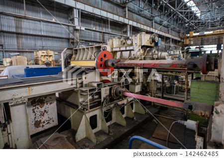 Industrial machinery in large factory with rusted metal and red accents under high ceiling Industrial machinery in large factory with rusted metal and red accents under high ceiling 142462485
