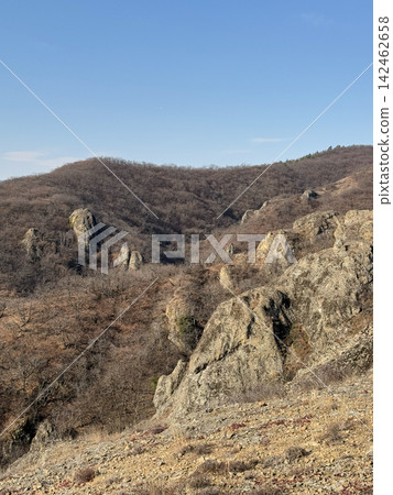 Rocky mountain slopes with bare forest under bright daylight sky. Rocky mountain slopes with bare forest under bright daylight sky. 142462658