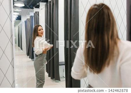 Smiling Woman Trying On Jeans In Clothing Store Smiling Woman Trying On Jeans In Clothing Store 142462878
