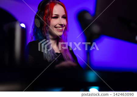 Young female gamer streaming live in a vibrant gaming studio Young female gamer streaming live in a vibrant gaming studio 142463090