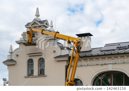 Historic Building Facade Maintenance Worker Using Aerial Boom Lift for Exterior Restoration and Repair Historic Building Facade Maintenance Worker Using Aerial Boom Lift for Exterior Restoration and Repair 142463150