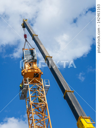 Tower Crane Operator Cab Installation by Mobile Crane with Workers Guiding Assembly High Above Ground Tower Crane Operator Cab Installation by Mobile Crane with Workers Guiding Assembly High Above Ground 142463163