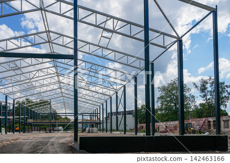 Steel Frame Structure of Large Industrial Building Under Construction at Urban Development Site Steel Frame Structure of Large Industrial Building Under Construction at Urban Development Site 142463166