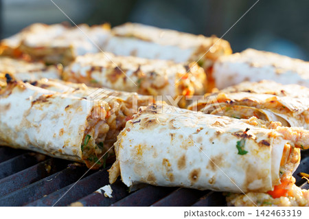 Delicious grilled wraps filled with fresh ingredients cooking outdoors Delicious grilled wraps filled with fresh ingredients cooking outdoors 142463319