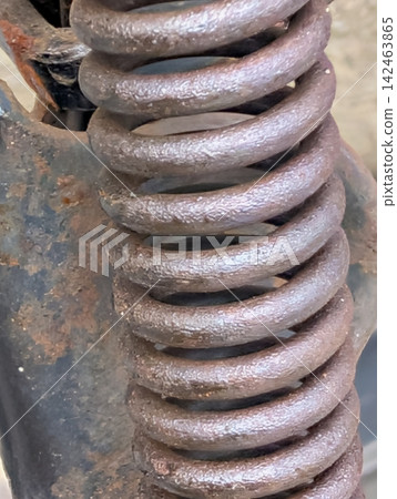 鏽跡斑斑的大型螺旋彈簧特寫 / 象徵機械、工業和老化的金屬零件和材料。 142463865
