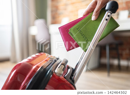 Girl Rolling A Suitcase Holding Passports Girl Rolling A Suitcase Holding Passports 142464302