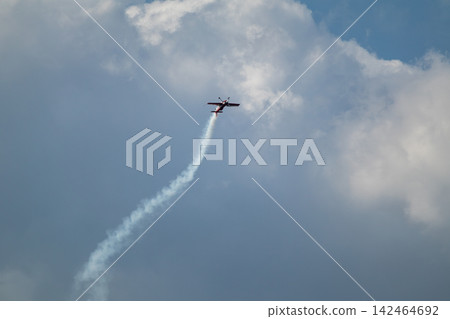 Stunt airplane ascends into cloudy sky Stunt airplane ascends into cloudy sky 142464692