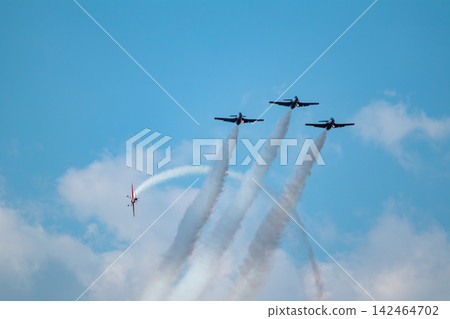 Red stunt plane circles three jets in flight show Red stunt plane circles three jets in flight show 142464702