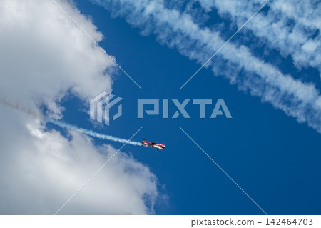 Aerobatic red plane flying high in clouds Aerobatic red plane flying high in clouds 142464703