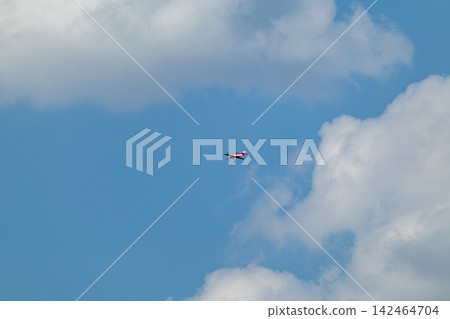Red light airplane flying through scenic clouds Red light airplane flying through scenic clouds 142464704