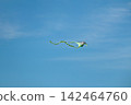 Kite flying under bright sun and clouds 142464760