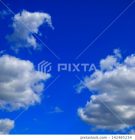 white cumulus clouds framing the sides of a deep rich blue sky view white cumulus clouds framing the sides of a deep rich blue sky view 142465234