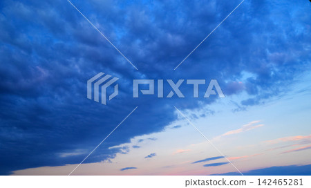 dark blue evening sky with deep blue clouds and soft pink feathered clouds near the horizon dark blue evening sky with deep blue clouds and soft pink feathered clouds near the horizon 142465281